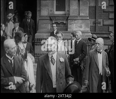 Le roi George V accompagné d'un groupe de fonctionnaires sortant d'un bâtiment , 1924. De "Time to Remember - A Trip to Europe", 1924 (bobine 2) ; un regard sur la vie politique et sociale en Europe et au-delà en 1924. Banque D'Images