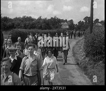 Un grand groupe de randonneurs marchant dans la campagne, 1931. '...le premier des années trente, quand nous étions heureux quand nous faisions de la randonnée. Fini l'agitation indécise d'après-guerre des années vingt. Avec la nouvelle ère, nous avancerions, dans la paix et la raison, vers un avenir raisonnablement rose ». De "Time to Remember - A New Era", 1931 (bobine 1) ; documentaire sur le monde au début des années 1930 Banque D'Images