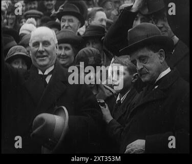 Sir James Barrie debout avec une foule de gens, 1921. De "Time to Remember - The Time When Little Happen", 1921 (bobine 2) ; événements de 1921 - traité irlandais, cascades folles et journaux au travail. Banque D'Images