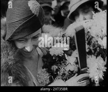 Elizabeth, sa Majesté la Reine des Belges recevant des fleurs, années 1930 De "Time to Remember - The Powers That Were", années 1930 (bobine 1) ; un documentaire sur diverses figures importantes des années 1930 Banque D'Images