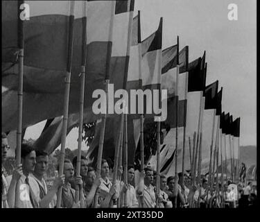 Hitler Youth Members Holding Flags, années 1930 De "Time to Remember - The Powers That Were", années 1930 (Reel 3) ; un documentaire sur diverses figures importantes des années 1930 Banque D'Images