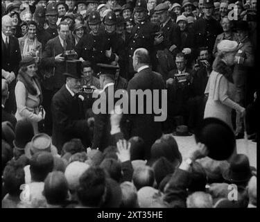 Roi George V et autres hommes et femmes bien habillés marchant dans une foule avec des photographes regardant, 1933. De "Time to Remember - The Time of the Monster", 1933 (bobine 1) ; film documentaire sur les événements de 1933, la montée de Roosevelt et Hitler. Banque D'Images