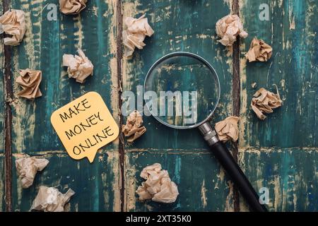 Une note jaune sur une table avec une loupe et une pile de papier. La note dit faire de l'argent en ligne Banque D'Images