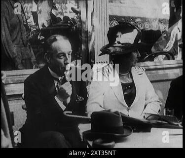 Le président britannique de la Chambre de commerce Stanley Baldwin avec sa femme Lucy Baldwin dans un café en France, 1922. «...les conservateurs ont décidé de briser la coalition et de se débrouiller seuls, pour le mandat du pays. Leur chef était Mr. Bonar Law. Mais le véritable pouvoir derrière cette poussée était un nouveau venu, Stanley Baldwin, et derrière ce tuyau et cette expression bénigne, il y avait un esprit assez vif pour surprendre le pays ». De "Time to Remember - Sitting Still and Going Slowly", 1922 (Reel 2) ; revue des événements de 1922, y compris les troubles irlandais, la guerre entre la Grèce et la Turquie et les développements dans l'aviation et la radio. Banque D'Images