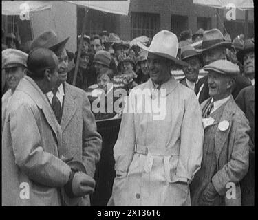 Les vedettes du cinéma muet Douglas Fairbanks, Will Rogers et Tom Mix posant pour la caméra avec une foule, 1921 ans. De "Time to Remember - The Time When Little Happen", 1921 (bobine 3) ; événements de 1921 - traité irlandais, cascades folles et journaux au travail. Banque D'Images