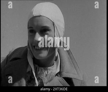 Jean Batten dans Flying Gear souriant aux foules, années 1930 De "Time to Remember - Some People in the Thirties", années 1930 (Reel 2) ; film documentaire sur les années 1930, mettant l'accent sur les personnages célèbres de l'époque. Banque D'Images