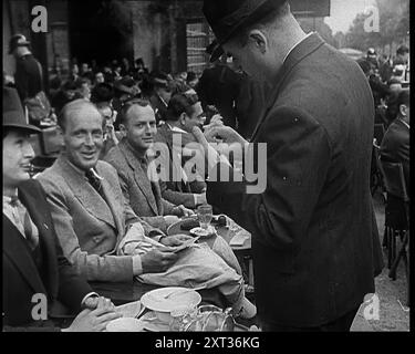 Police française vérifiant les papiers des gens devant un café à Paris, 1940. Seconde Guerre mondiale. 'Paris, mai 1940. À l'apparence extérieure, Paris comme d'habitude. Mais intérieurement, nerveux, appréhensif. Le long des champs Elys&#xe9;es et des grands boul&#xe9;vards, la police vérifie les papiers d'identité, car la France est maintenant saisie par la peur des chroniqueurs de la Cinquième. Quoi que les nouvelles coulent du front, c'est de la confusion et de la retraite. La ville vivante de rumeurs, vraies et fausses... alors Paris espère, et se commande un autre ap&#xe9;ritif. Espère, et met un bon visage sur elle». De "Time to Remember - Run Rabbit Run", 1940 ( Banque D'Images