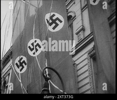 Drapeaux de bannière nazie allemands suspendus à la façade d'un bâtiment, 1939. De "Time to Remember - The Reluctant Warriors", 1939 (bobine 1) ; documentaire sur les événements de 1939 - les préparatifs de la guerre et les hostilités éclatent. Banque D'Images