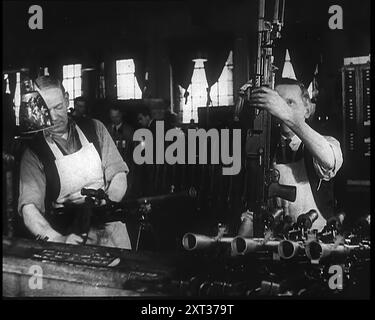 Deux hommes fabriquant des mitrailleuses dans une usine, 1940. La Grande-Bretagne pendant la seconde Guerre mondiale. '...affamé de métal factories...now bourdonnement pour remplacer toutes les armes et l'équipement laissés par le corps expéditionnaire britannique sur les plages sanglantes de Dunkerque, et aussi pour équiper et équiper de nouvelles armées une fois qu'elles ont été formées'. De "Time to Remember - Standing Alone", 1940 ( bobine 1) ; film documentaire sur les événements des derniers mois de 1940. Banque D'Images