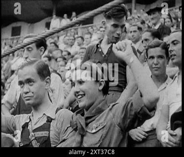 Spectateurs de Bullring Cheering Parading Government Fighters, y compris Woman with Raised Left Fist, 1937. Guerre civile espagnole. L'Espagne '... arènes pleines d'hommes et de femmes désirant non pas le sang de "toros", mais de l'ennemi'. De "Time to Remember - Sense of Values", 1937 (Reel 2) ; film documentaire sur les événements de 1937, la guerre en extrême-Orient, construire à la guerre en Europe. Banque D'Images