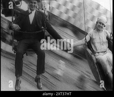 Un civil masculin et un civil féminin se tenant la main alors qu'ils sont Spun Through the Air on a Fair Ground Ride, 1924. De "Time to Remember - A Trip to Europe", 1924 (bobine 3) ; un regard sur la vie politique et sociale en Europe et au-delà en 1924. Banque D'Images