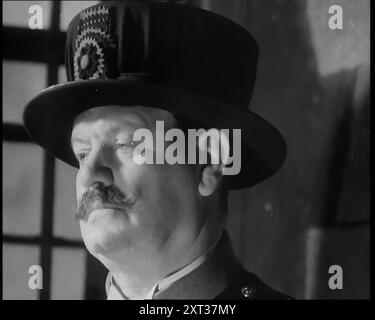 Beefeater gardant les joyaux de la Couronne à la Tour de Londres, 1937. "Une fois de plus, c'était un trésor étroitement gardé qui devait être temporairement retiré de la Tour de Londres, car une fois de plus un sens des valeurs exigeait qu'il soit placé sur une tête." De "Time to Remember - Sense of Values", 1937 (bobine 1) ; film documentaire sur les événements de 1937, la guerre en extrême-Orient, construire à la guerre en Europe. Banque D'Images