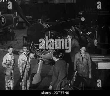 Ouvriers d'usine inspectant un Spitfire en construction, 1940. La Grande-Bretagne pendant la seconde Guerre mondiale. Soir et nuit, pleurnements de forets et le robinet de marteaux dans les usines Spitfire. Ce n'est que par un effort de 24 heures que les pertes peuvent être compensées, et un jour, si Dieu le veut, la défensive peut être abandonnée pour l'offensive. Temps plein, heures supplémentaires, temps double ». De "Time to Remember - Standing Alone", 1940 (bobine 4) ; film documentaire sur les événements des derniers mois de 1940. Banque D'Images