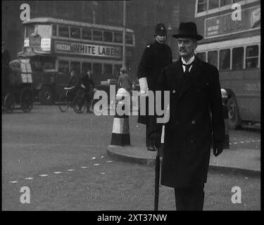 Neville Chamberlain, politicien britannique, traversant une rue de Londres, 1937. Les hommes d'État s'occupaient des affaires [de la Grande-Bretagne], et il y avait beaucoup à faire. Car le monde en dehors de la Grande-Bretagne, le couronnement de 1937 a été agité, en constante évolution, inquiétant et plein de doutes et de craintes. Chamberlain est premier ministre du Royaume-Uni de mai 1937 à mai 1940. De "Time to Remember - Sense of Values", 1937 (bobine 1) ; film documentaire sur les événements de 1937, la guerre en extrême-Orient, construire à la guerre en Europe. Banque D'Images