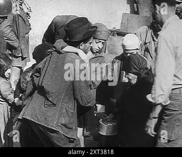 Des civils italiens reçoivent l'aide de soldats américains dans une ville italienne endommagée par une bombe, 1943-1944. De "Time to Remember - The Path to Rome", 1943 - 1944 (bobine 1) ; film documentaire sur les événements de 1943 et 1944 - la campagne italienne. Banque D'Images