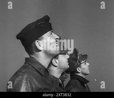 Un groupe de pilotes masculins observant des avions dans le ciel, 1943-1944. De "Time to Remember - Round the Clock", 1943 - 1944 ( bobine 1) ; film documentaire sur les événements de 1943-1944, principalement des missions de bombardement au-dessus de l'Europe. Banque D'Images