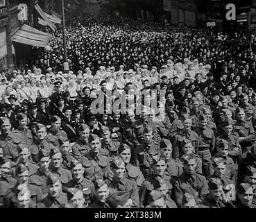 Une foule de soldats écoutant Max Aitken, 1er baron Beaverbrook, prononcer un discours de soutien à l'URSS, Birmingham, 1942. La Grande-Bretagne pendant la seconde Guerre mondiale. Lord Beaverbrook: "Nous croyons en la compétence des généraux russes. Nous croyons en l'équipement des divisions russes. Et nous croyons en la puissance combattante et au courage des soldats russes. Et nous croyons au leadership de Staline. Et c'est le jour pour proclamer notre foi. Livrons une bataille acharnée à notre ennemi. Bataille dans leurs propres terres, bataille sur le deuxième front". De "temps de se souvenir - la fin de la mendicité Banque D'Images