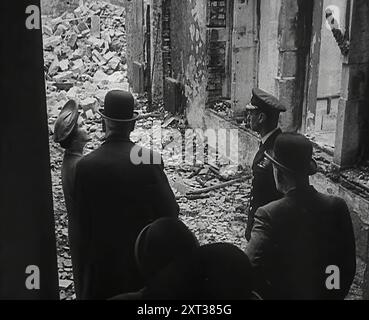 Le roi George VI et la reine Elizabeth inspectent les dégâts causés par la bombe, 1942. La Grande-Bretagne pendant la seconde Guerre mondiale. De "Time to Remember - The End of the Beginning", 1942 (bobine 1) ; film documentaire sur les événements de 1942 et l'entrée de l'Amérique dans la guerre. Banque D'Images