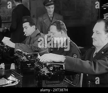 Journalistes en uniforme travaillant, 1943. De "Time to Remember - Struggle for A Planet", 1943 ( Reel 2) ; film documentaire sur les événements de 1943, en particulier la bataille de l'Atlantique. Banque D'Images