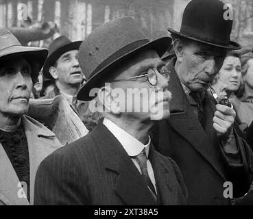 Foules écoutant des discours à Trafalgar Square, 1942. La Grande-Bretagne pendant la seconde Guerre mondiale. 'Dans Trafalgar Square de Londres'... une rencontre passionnée avec des indications de sentiments forts de millions de personnes. Ripostez maintenant et soulagez la Russie assiégée... peut-être jamais auparavant dans l'histoire du monde n'a-t-il semblé si uni dans la résolution de ses millions. Pour l'homme de la rue... sacrifices, pénuries et économies. De "Time to Remember - The End of the Beginning", 1942 ( Reel 2) ; film documentaire sur les événements de 1942 et l'entrée de l'Amérique dans la guerre. Banque D'Images