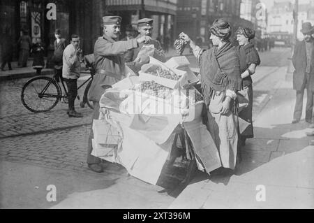 Soldats allemands achetant des fruits, Belgique, 1915. Montre des soldats allemands achetant des raisins à des femmes avec un chariot de rue en Belgique pendant la première Guerre mondiale Banque D'Images