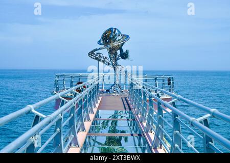 Comté d'Uljin, Corée du Sud - 27 juillet 2024 : le reflet de la sculpture de sirène et de vague scintille sur la passerelle à fond de verre Deunggi Mountain Skywalk, Banque D'Images