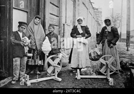 Erivan : ramasser les roues à filer &amp ; coton, entre c1915 et c1920. Montre des femmes et des garçons arméniens à l'extérieur du bâtiment, Erevan, Arménie. Banque D'Images