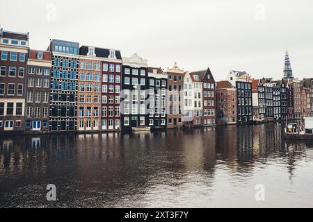 L'architecture hollandaise traditionnelle borde le canal à Amsterdam, pays-Bas, avec une gamme de maisons colorées avec des façades uniques sous un s couvert Banque D'Images