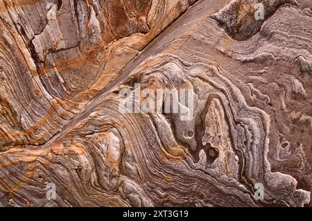 Une vue rapprochée d'une falaise au bord de la mer, montrant des motifs naturels complexes et des textures. L'image capture le beau contraste entre les couches Banque D'Images