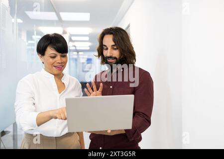 Un professionnel masculin et féminin utilisant une tablette pour discuter du travail, révélateur du travail d'équipe dans un environnement éducatif moderne Banque D'Images