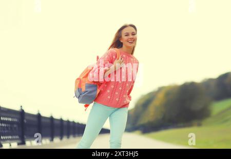 Heureux rire jeune femme sur des promenades en patins à roulettes dans le parc de la ville Banque D'Images