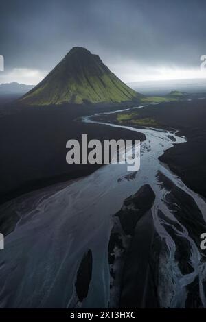 Une superbe photographie aérienne capturant le majestueux volcan Maelifell, entouré de sables volcaniques sombres et de ruisseaux contrastés dans la lointaine Islande Banque D'Images