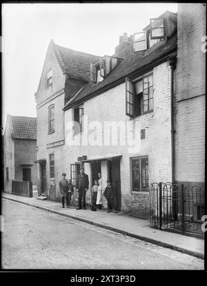 Brewhouse Lane, Putney, Wandsworth, Greater London Authority, 1910. Un groupe debout devant une maison sur Brewhouse Lane avec les balustrades de la maison publique du château à droite. Banque D'Images