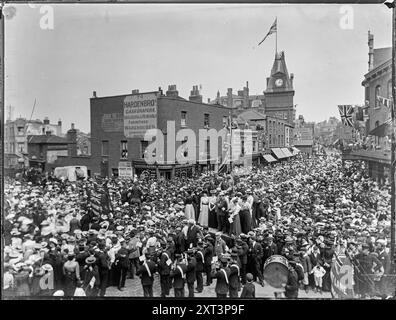 Wandsworth High Street, Wandsworth, Wandsworth, Greater London Authority, 1890-1910 foules se sont rassemblées pour assister à une procession de l'école du dimanche sur Wandsworth High Street, près des jonctions de Ram Street et Garratt Lane. Dans cette scène, le photographe regarde vers le nord-est le long de Wandsworth High Street avec le Spread Eagle Hotel sur la droite et la tour de l'horloge de la mairie au centre de la photo. Le 'Town Hall Coffee & amp ; Chop House' vu sur la gauche est au coin de Ram Street. Banque D'Images