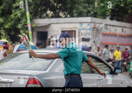 Un officier de la police de la circulation du Bangladesh donne des instructions aux conducteurs après que la police a annulé leur grève et repris leurs fonctions à la suite d'une réunion avec le gouvernement intérimaire. La police bangladaise a repris ses patrouilles dans la capitale Dacca, mettant fin à une grève d'une semaine qui a laissé un vide juridique et de l'ordre après l'éviction brutale de l'ancien premier ministre autocratique Sheikh Hasina. Banque D'Images