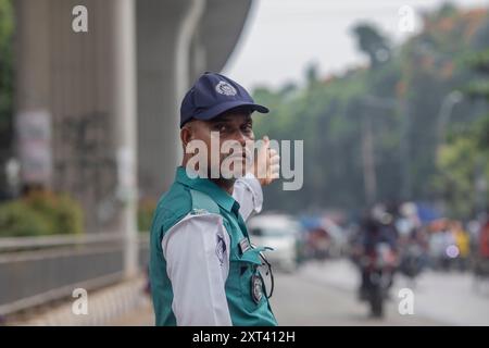 Dhaka, Bangladesh. 12 août 2024. Un officier de la police de la circulation du Bangladesh contrôle la circulation dans un carrefour après que la police a annulé sa grève et repris ses fonctions à la suite d'une réunion avec le gouvernement intérimaire. La police bangladaise a repris ses patrouilles dans la capitale Dacca, mettant fin à une grève d'une semaine qui a laissé un vide juridique et de l'ordre après l'éviction brutale de l'ancien premier ministre autocratique Sheikh Hasina. (Photo de Sazzad Hossain/SOPA images/SIPA USA) crédit : SIPA USA/Alamy Live News Banque D'Images