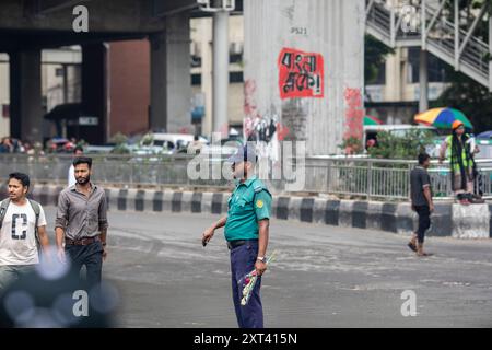 Dhaka, Bangladesh. 12 août 2024. Un officier de la police de la circulation du Bangladesh contrôle la circulation dans un carrefour après que la police a annulé sa grève et repris ses fonctions à la suite d'une réunion avec le gouvernement intérimaire. La police bangladaise a repris ses patrouilles dans la capitale Dacca, mettant fin à une grève d'une semaine qui a laissé un vide juridique et de l'ordre après l'éviction brutale de l'ancien premier ministre autocratique Sheikh Hasina. (Photo de Sazzad Hossain/SOPA images/SIPA USA) crédit : SIPA USA/Alamy Live News Banque D'Images