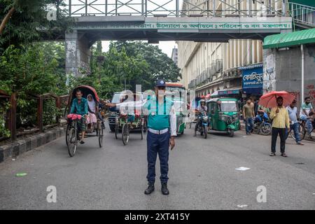 Dhaka, Bangladesh. 12 août 2024. Un officier de la police de la circulation bangladaise conteste la circulation dans un carrefour après que la police a annulé sa grève et repris ses fonctions après une réunion avec le gouvernement intérimaire. La police bangladaise a repris ses patrouilles dans la capitale Dacca, mettant fin à une grève d'une semaine qui a laissé un vide juridique et de l'ordre après l'éviction brutale de l'ancien premier ministre autocratique Sheikh Hasina. (Photo de Sazzad Hossain/SOPA images/SIPA USA) crédit : SIPA USA/Alamy Live News Banque D'Images