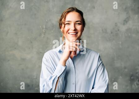 Jeune femme professionnelle confiante souriante. Jeune professionnel dynamique souriant en toute confiance devant la caméra. Idéal pour promouvoir un travail positif Banque D'Images
