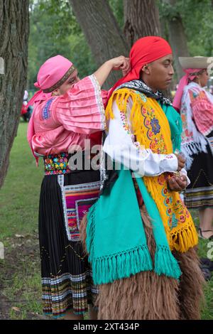 Une danseuse du groupe de danse Sentimiento Andino NY ajuste une écharpe des autres membres avant leur performance au Festival du patrimoine équatorien. Banque D'Images