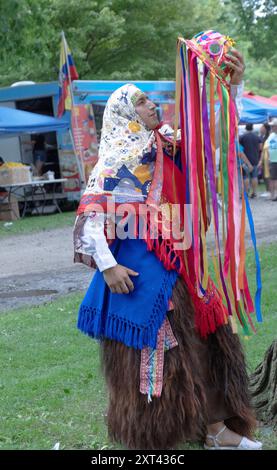 Portrait posé d'un danseur dans la troupe Sentimiento Andino NY tenant un costume coloré comprenant un chapeau Kichwa avec des rubans suspendus. À Westchester. Banque D'Images