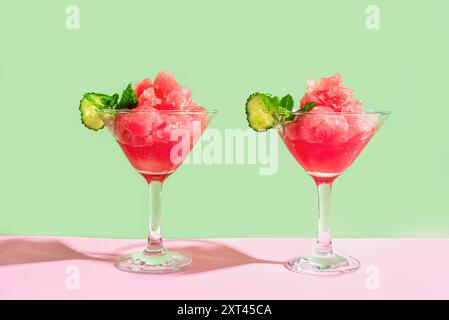 Slushie de pastèque ou cocktail granita avec menthe dans deux verres sur fond tendance rose et vert. Rafraîchissante boisson glacée rasée d'été ou Banque D'Images