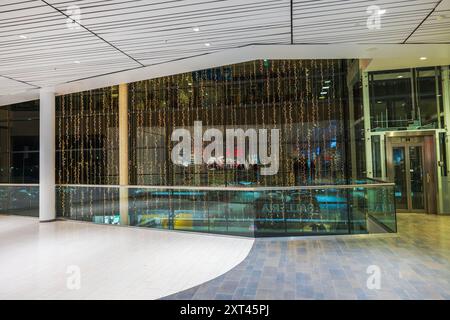 Salle d'hypermarché au deuxième étage avec guirlandes lumineuses de Noël suspendues à de grandes fenêtres panoramiques, reflétant la vue floue des étages. Suède. Banque D'Images