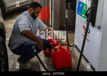 Caguas, États-Unis. 13 août 2024. Les Portoricains remplissent leurs voitures et leurs bidons d'essence supplémentaires pour se préparer à la tempête tropicale Ernesto à Caguas, Porto Rico, le 13 août 2024. La tempête tropicale Ernesto devrait frapper l'archipel entre mardi soir et mercredi matin. Crédit : Sipa USA/Alamy Live News Banque D'Images