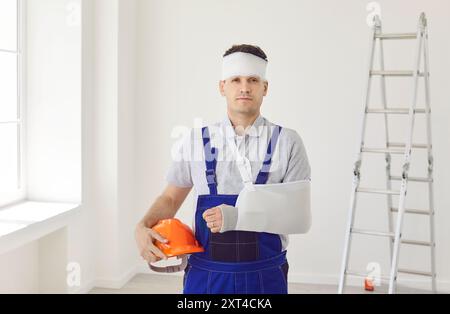 Portrait du constructeur qui a eu une fracture de bras et une blessure à la tête pendant les travaux de construction Banque D'Images