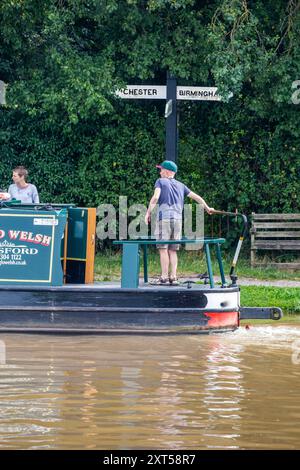 Bateau étroit sur le canal Shropshire union en passant un panneau pour Chester et Birmingham Banque D'Images