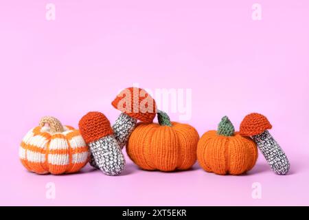 Composition d'automne de citrouilles orange tricotées et rayées, champignons sur fond violet. Concept d'automne, Thanksgiving, récolte, Halloween Banque D'Images