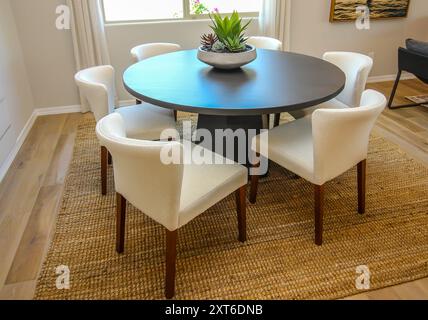 Table à manger ronde en bois avec six chaises en tissu Banque D'Images