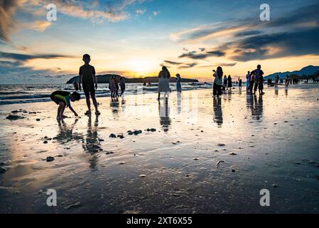 Langkawi Island, Malaisie-mai 05 2023 : comme le soleil se couche derrière les petites îles au large de la côte ouest de Langkawi, beaucoup de gens se rassemblent le long du bord de mer, à Banque D'Images