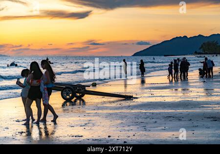 Langkawi Island, Malaisie-mai 05 2023 : comme le soleil se couche derrière les petites îles au large de la côte ouest de Langkawi, beaucoup de gens se rassemblent le long du bord de mer, à Banque D'Images